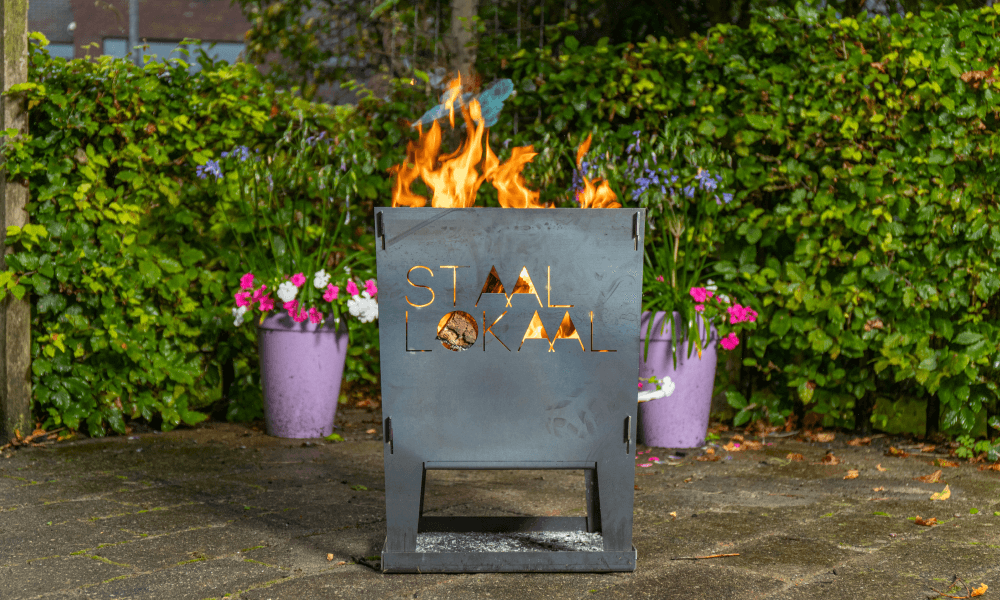 Brandende cortenstaal vuurkorf met het logo van Staallokaal