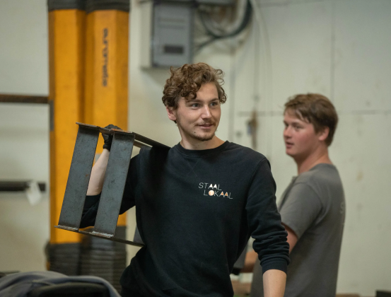 Thomas Leseman draagt staal door de werkplaats