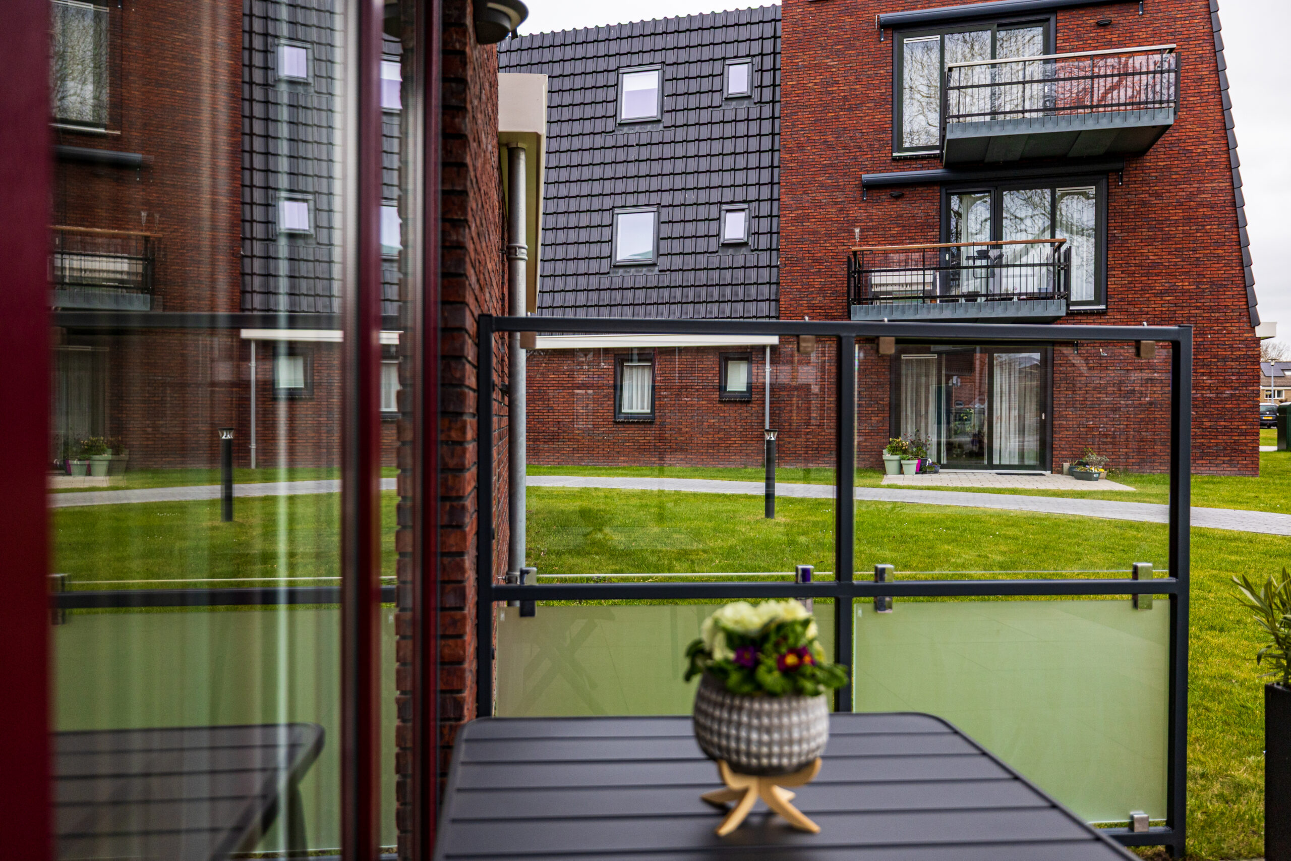 Uitzicht door een windscherm van Staallokaal met matglas