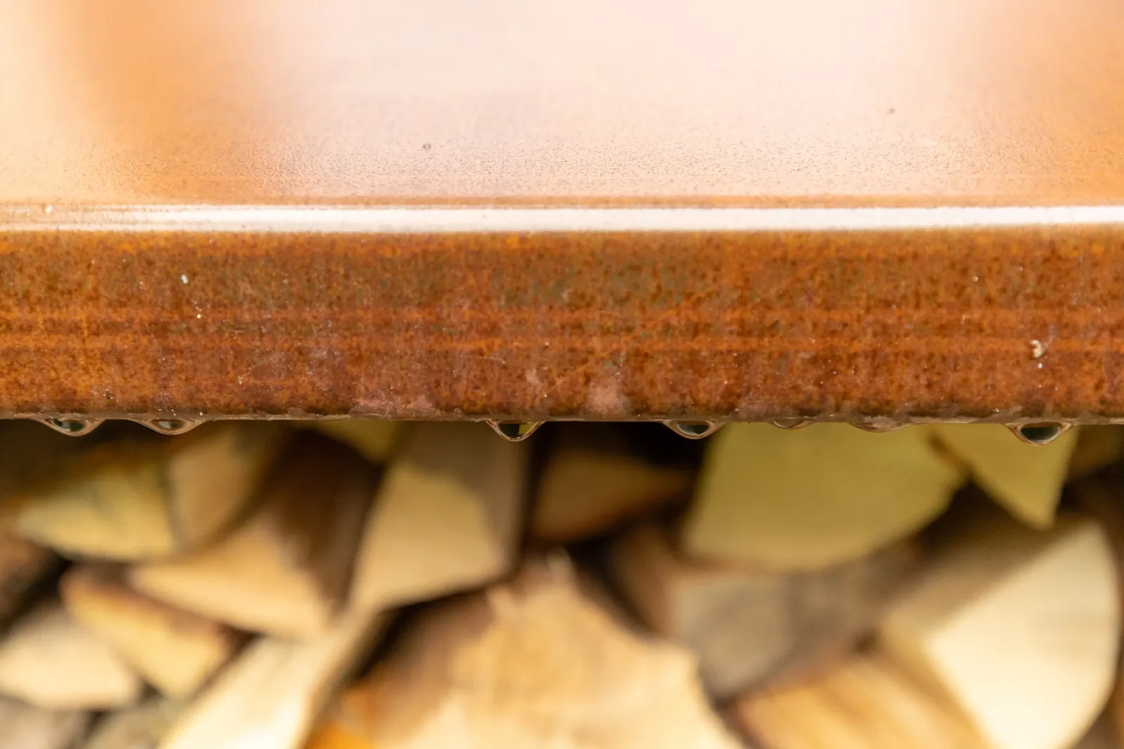 Detail van de cortenstalen rand van de houtopslag