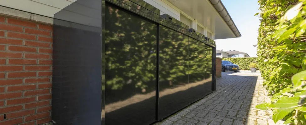Zwarte containerombouw van Staallokaal langs de oprit