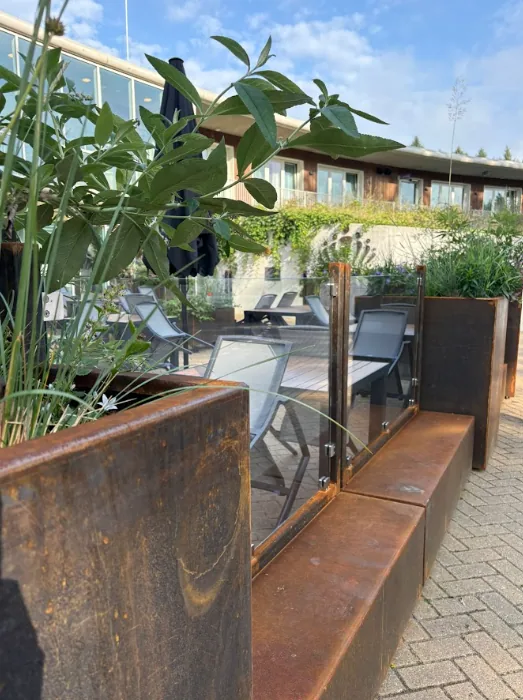 Cortenstalen plantenbak met glazen windscherm erboven