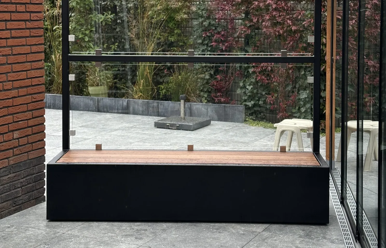 Windscherm van Staallokaal boven een houten zitbank